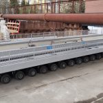 Selbstfahrender Modultransporter mit 72 Achsen bringt den Stahlüberbau vom Hafen zur Baustelle